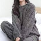 Femme assise en tailleur portant un pyjama en pilou pilou gris